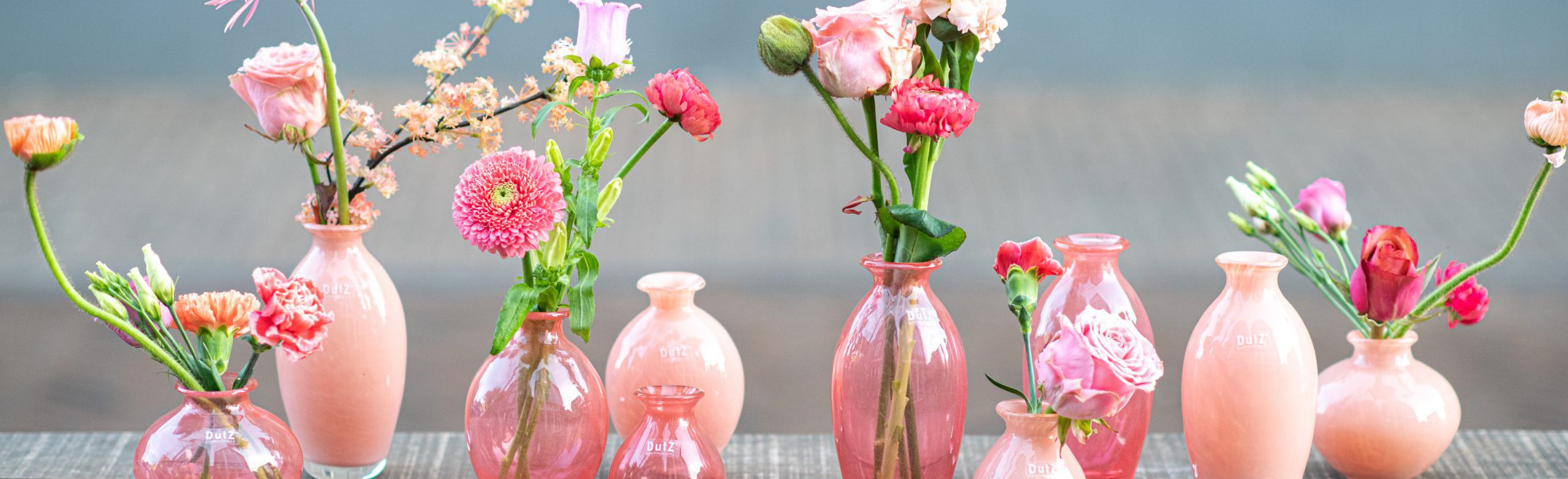 DutZ_nadiel_apricot_3 Nadiel vases in different shades of pink on a table. Filled with pink flowers