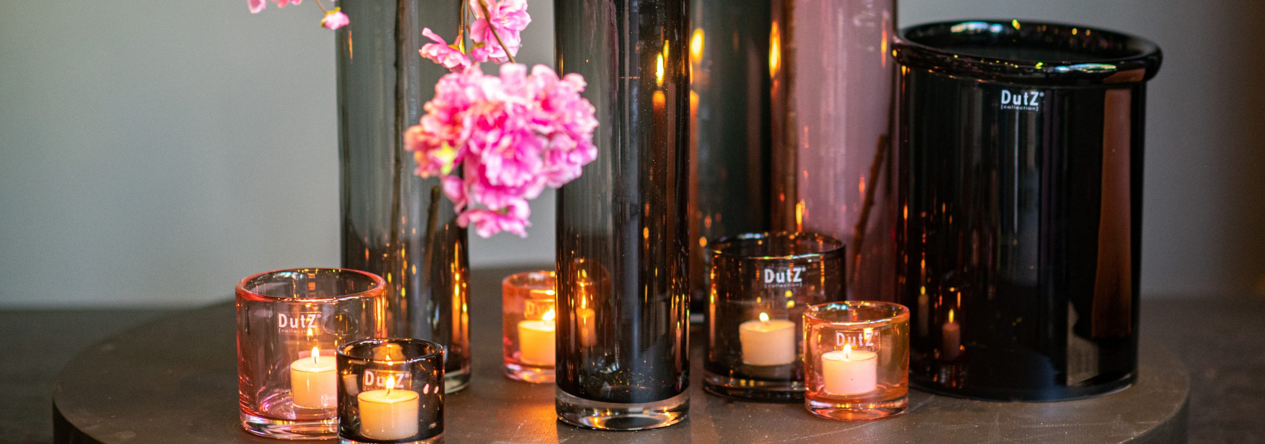 DutZ glass tea light holders in the colours pink and smoke. The cylinder have different sizes